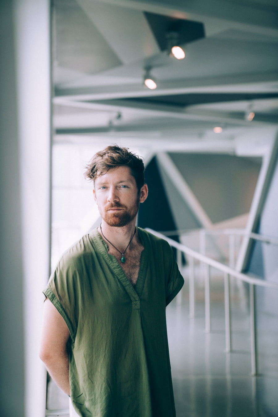Man in a loose olive green linen shirt