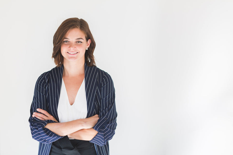 Woman in a navy pinstripe blazer with arms crossed