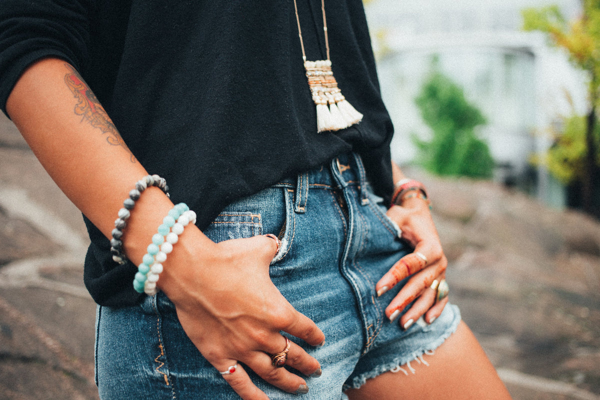 Woman in high-rise frayed denim shorts with hands in pockets